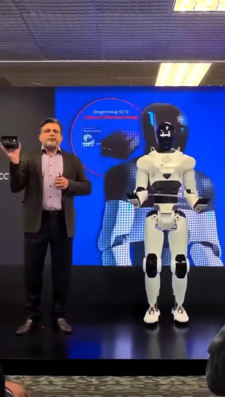 A presenter stands next to a humanoid robot during a recent technology demonstration before the reported malfunction.